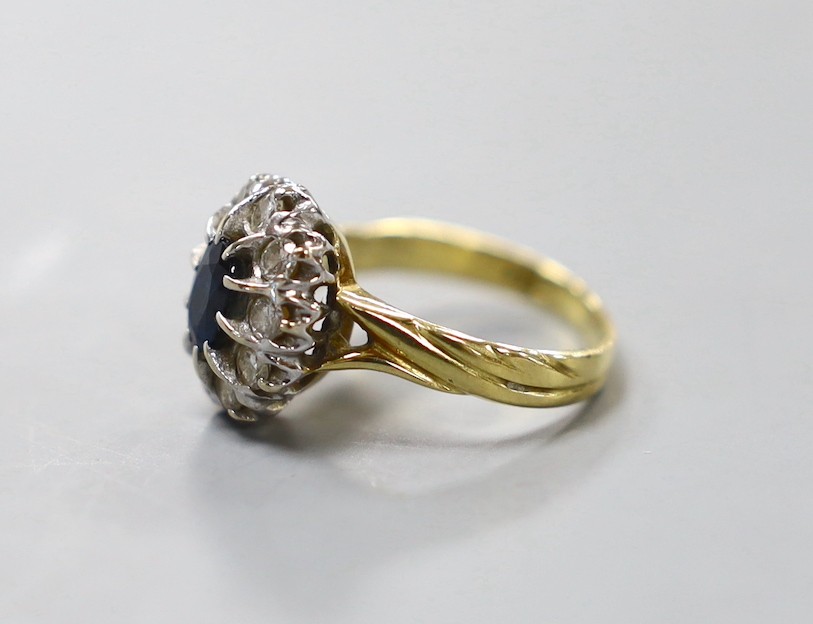 A modern 18ct gold, sapphire and diamond set oval cluster ring, size L, gross weight 4.6 grams.